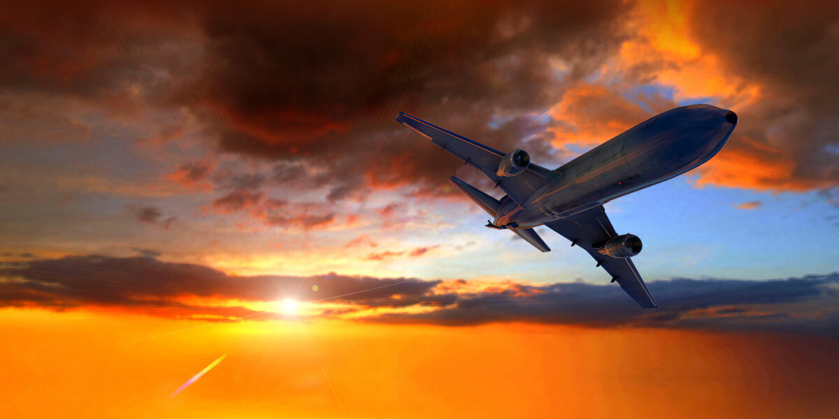 Avión volando en el atardecer Descripción generada automáticamente