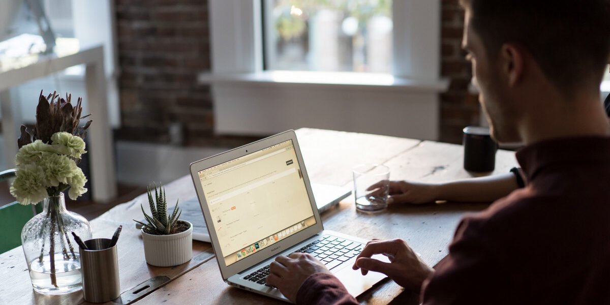 Un hombre sentado frente a una mesa con una computadora Descripción generada automáticamente con confianza baja