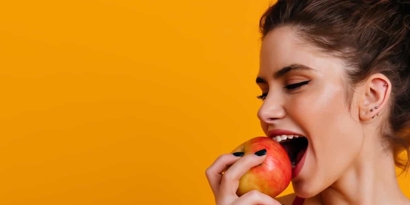 Un joven con una manzana en la boca Descripción generada automáticamente con confianza baja