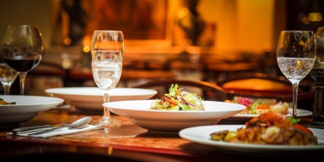 Un plato con comida y vino en una copa Descripción generada automáticamente